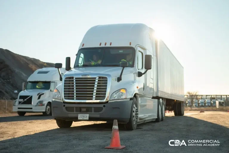 Front of CDA semi truck parked in yard, two instructors inside cab