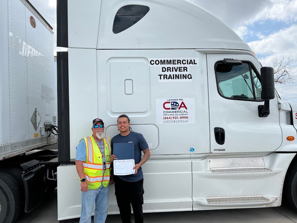 CDA graduate and instructor standing in front of CDA semi truck