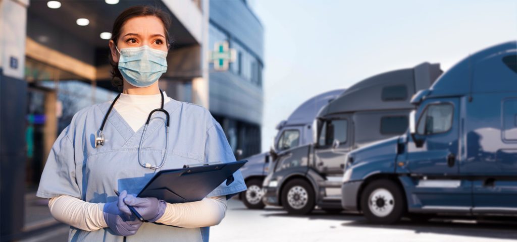 Doctor with mask on standing in front of three semi trucks lined up