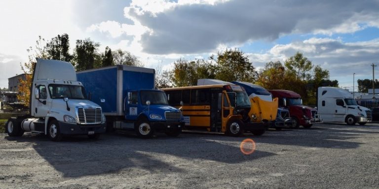 CDA semi trucks, box trucks, and buses parked next to each other in a training yard