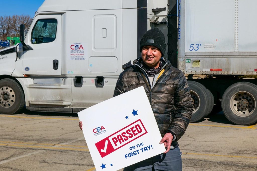 CDA student smiling and holding up a "I passed on my first try" sign