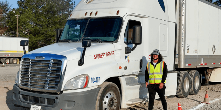 Graduate wearing safety vest standing in front of CDA semi truck