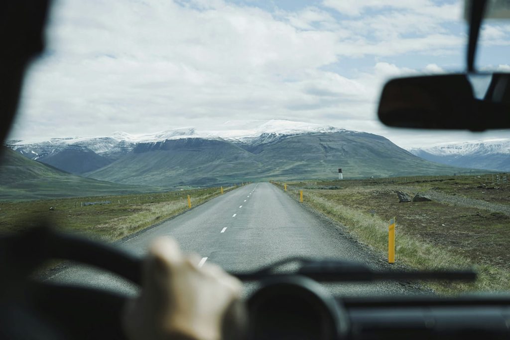 View of mountain tops and open road from inside of semi truck