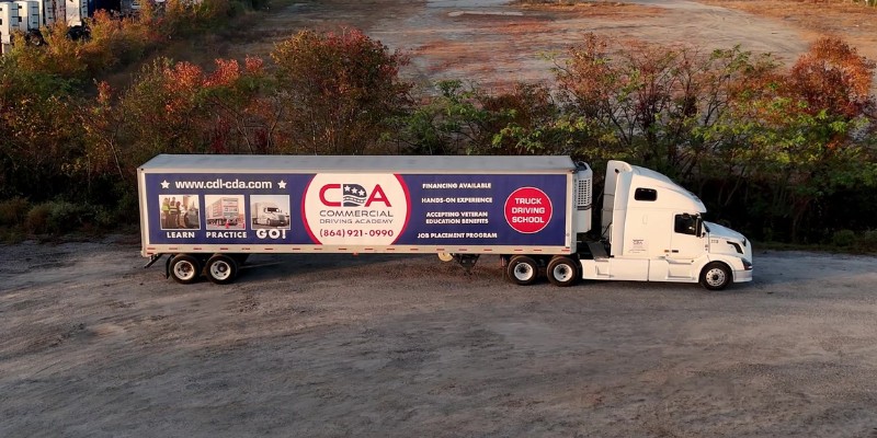 CDA semi truck driving through dirt training yard while sun is setting