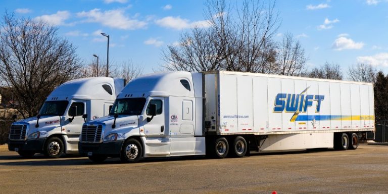 Two CDA Swift semi trucks parked side-by-side in a paved training lot