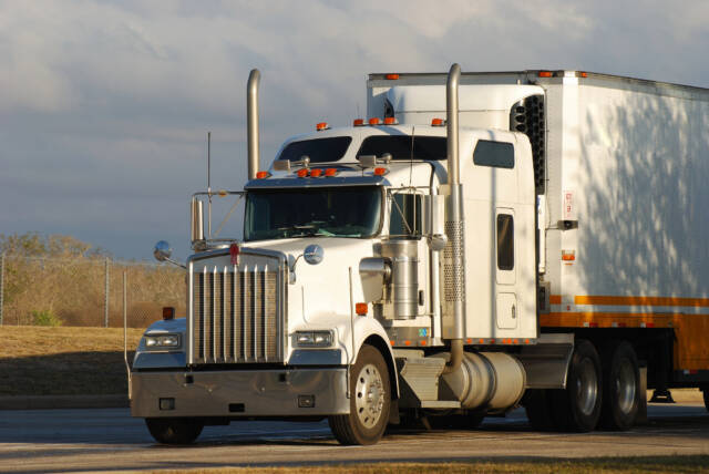 Truck on the road during the day. Side view.